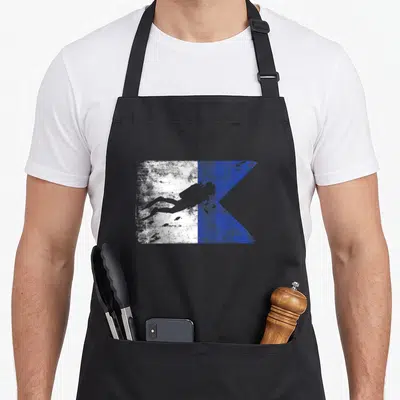 Tablier de cuisine noir avec un drapeau de plongée Alpha blanc et bleu comportant une silhouette de plongeur en apnée.