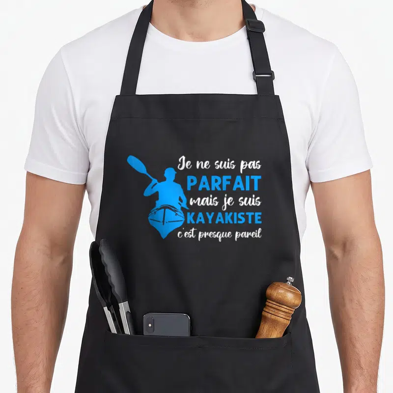 Tablier de cuisine noir avec silhouette bleue de kayakiste et texte Je ne suis pas parfait mais je suis kayakiste c'est presque pareil