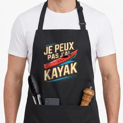 Tablier de cuisine noir avec un kayak rouge et le texte Je peux pas j'ai kayak imprimé en lettres capitales.