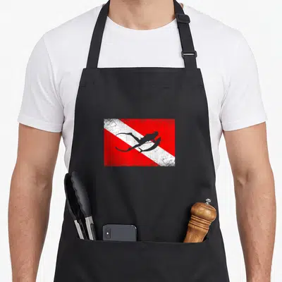 Tablier de cuisine noir avec drapeau de plongée rouge blanc et silhouette de chasseur sous-marin en gris.