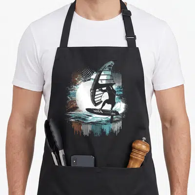 Tablier de cuisine noir avec illustration stylisée d'un surfeur en wing foil aux couleurs orange et turquoise.