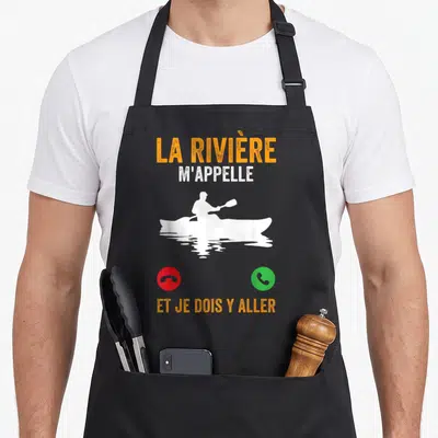 Tablier de cuisine noir avec silhouette blanche de kayakiste et texte orange sur fond uni.