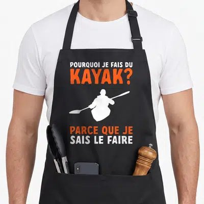 Tablier de cuisine noir avec une silhouette blanche de kayakiste et un texte humoristique en orange et blanc sur fond uni.