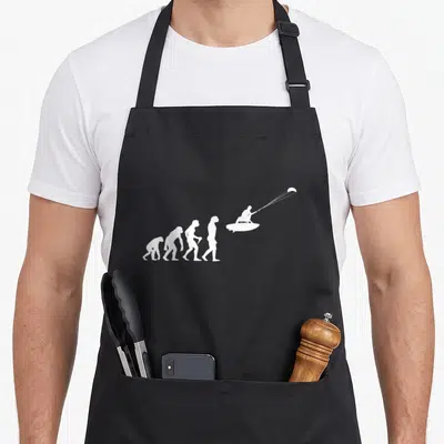 Tablier de cuisine noir avec silhouette blanche représentant l'évolution humaine jusqu'à un kitesurfeur en action.