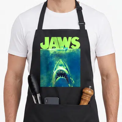 Tablier de cuisine noir avec illustration d'un shark sous l'eau et texte Jaws vert fluo