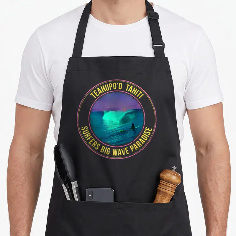 Tablier de cuisine noir avec un motif circulaire coloré représentant une grande vague et un surfeur au centre.