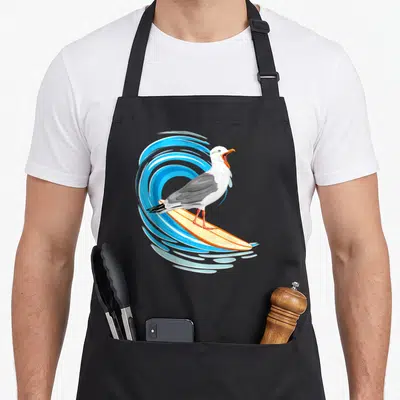 Tablier de cuisine noir avec mouette surfant sur planche jaune devant une vague bleue stylisée.