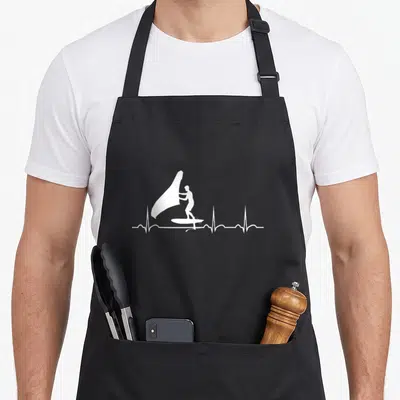 Tablier de cuisine noir avec silhouette blanche d'un wingfoiler sur une ligne de battement de cœur.