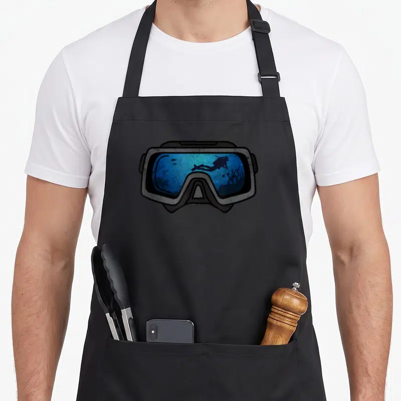 Tablier de cuisine noir avec illustration d'un masque de plongée montrant un scuba diver en silhouette sur fond bleu aquatique.