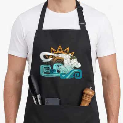 Tablier de cuisine noir avec illustration de Maui tenant son crochet au-dessus de vagues bleues et d'un soleil orange.