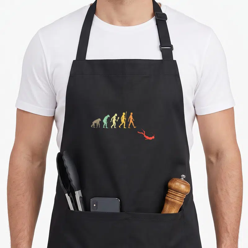 Tablier de cuisine noir avec silhouette évolution humaine et plongeur snorkeling rouge en bas à droite.