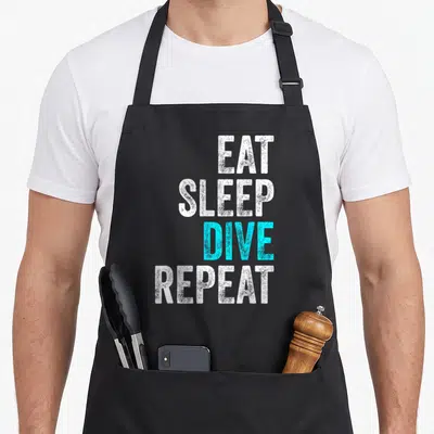Tablier de cuisine noir avec le texte Eat Sleep Dive Repeat en blanc et cyan