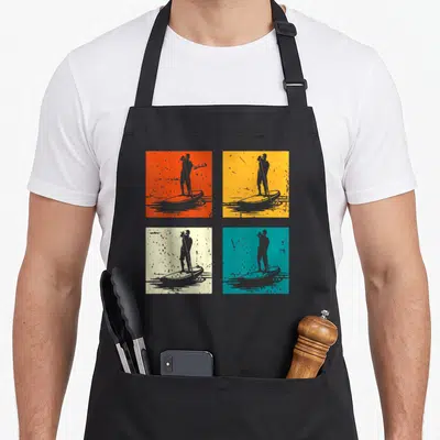 Tablier de cuisine noir avec quatre illustrations de planche à pagaie sur fonds colorés style pop art.