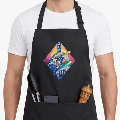 Tablier de cuisine noir avec illustration d'un crâne en SUP sur une grande vague bleue et un soleil orange dans un cadre géométrique.