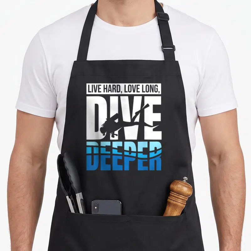 Tablier de cuisine noir avec le texte Live Hard Love Long Dive Deeper et une silhouette de plongeur en blanc et bleu.