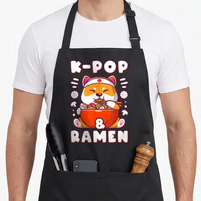 Tablier de cuisine noir avec illustration d'un Shiba Inu mangeant du ramen et du texte K-POP RAMEN