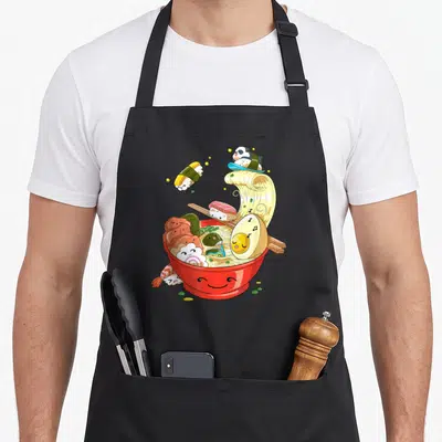 Tablier de cuisine noir avec illustration colorée d'un bol de ramen souriant, de sushis kawaii et d'un panda sur les noodles.