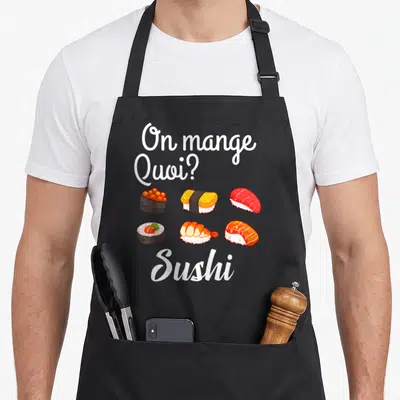 Tablier de cuisine noir avec On mange quoi Sushi et six pièces de nigiri colorées disposées en grille.