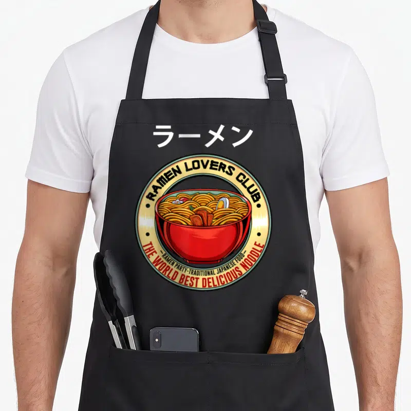 Tablier de cuisine noir avec un logo circulaire représentant un bol de ramen rouge et des caractères japonais en haut.