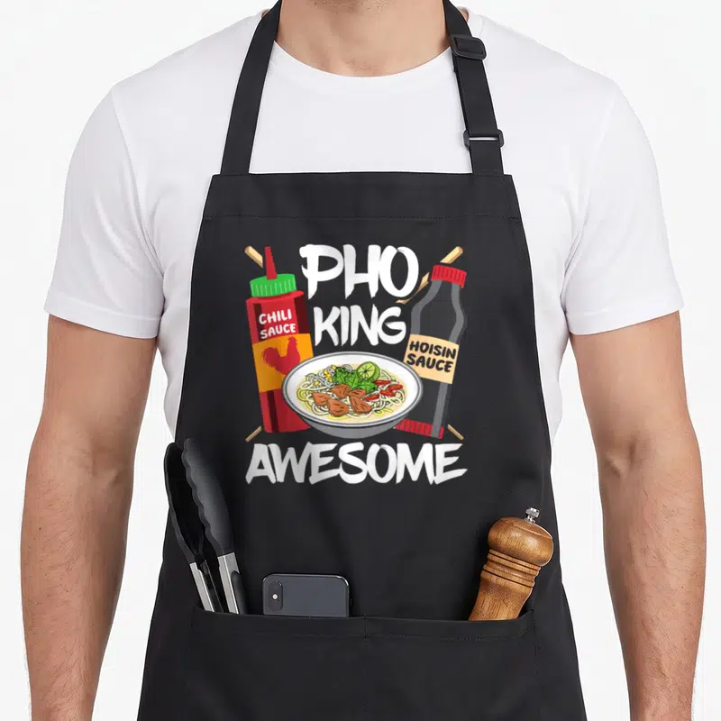 Tablier de cuisine noir avec illustration d'un bol de Pho King entouré de sauces et du mot Incroyable en lettres blanches.