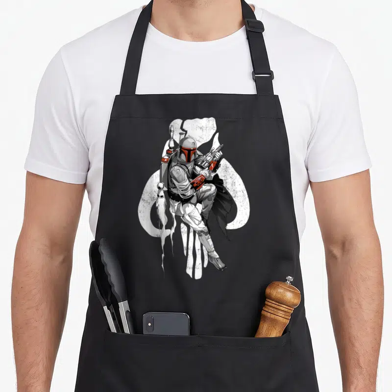 Tablier de cuisine noir avec illustration de Boba Fett et silhouette blanche de mythosaur en arrière-plan.