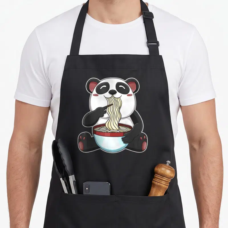 Tablier de cuisine noir avec illustration d'un panda mangeant des nouilles dans un bol bleu et rouge.
