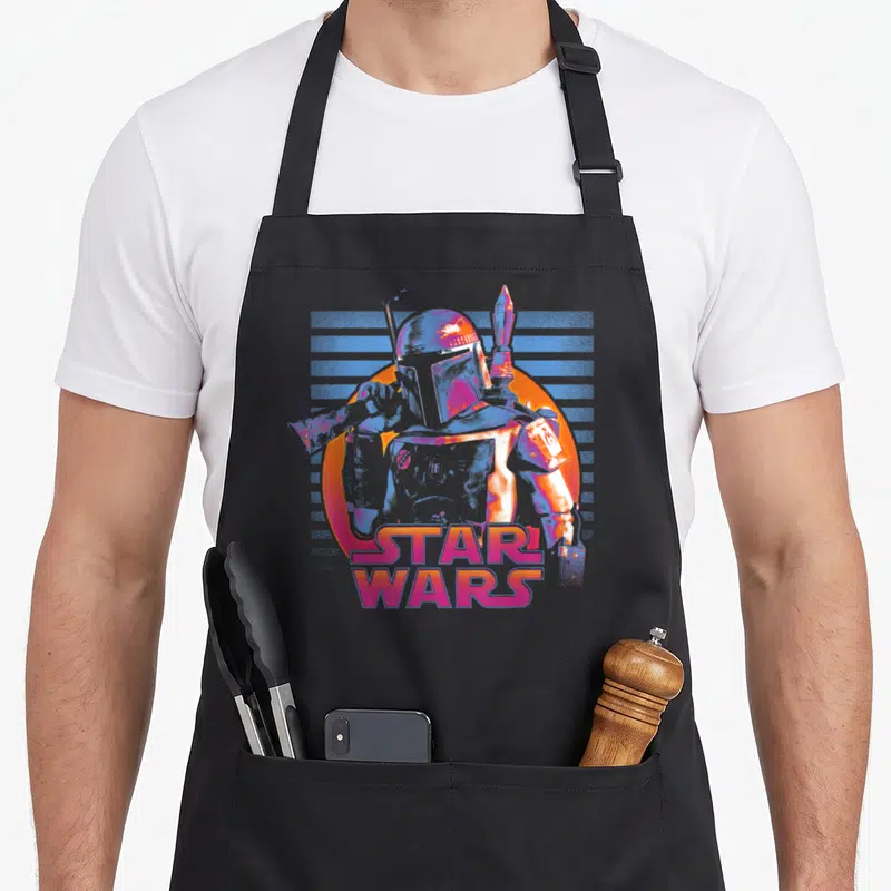 Tablier de cuisine noir avec illustration de Boba Fett en néon rose et bleu sur fond orange, texte Star Wars en bas.