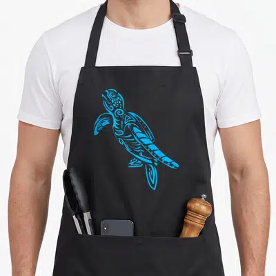 Tablier de cuisine noir avec une tortue de mer polynésienne stylisée en motifs tribaux bleus lumineux.