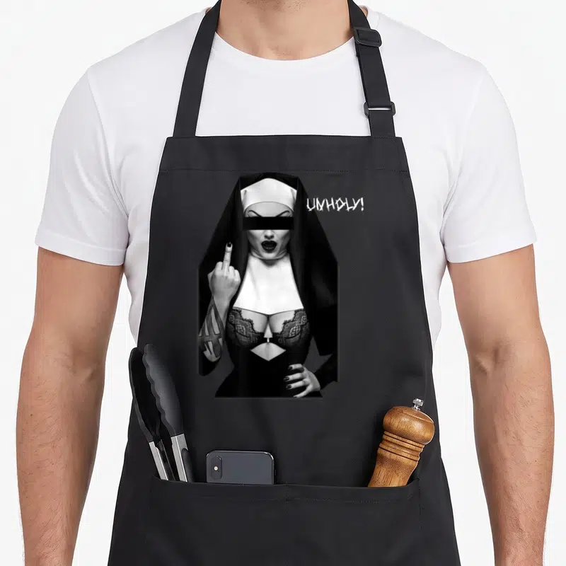 Tablier de cuisine noir avec illustration d'une nonne provocante au style tatouage et inscription Unholy.