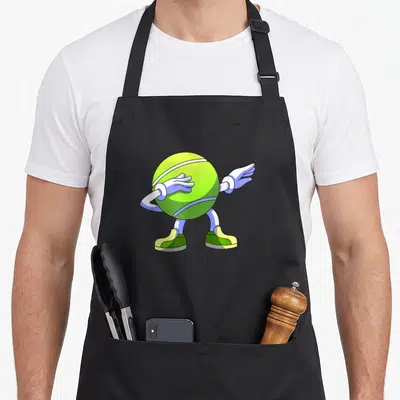 Tablier de cuisine noir avec une balle de tennis verte anthropomorphique effectuant un geste de dance moderne.