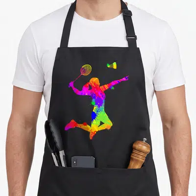Tablier de cuisine noir avec une silhouette de badmintonneuse aux couleurs vives et un volant jaune en l'air.