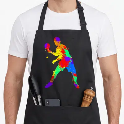 Tablier de cuisine noir avec silhouette d'athlète de ping-pong formée par des taches de peinture aux couleurs vives et contrastées.