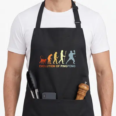 Tablier de cuisine noir avec illustration Evolution of Ping Pong et silhouettes évoluant vers un joueur de sport de table.