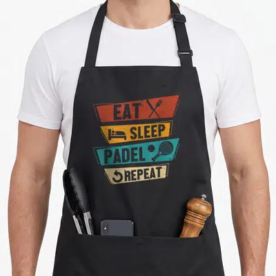 Tablier de cuisine noir avec bandes colorées Eat Sleep Padel Repeat et icônes de raquette et couverts croisés.