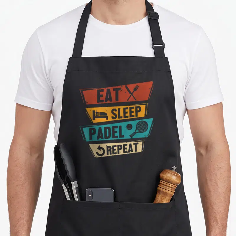 Tablier de cuisine noir avec bandes colorées Eat Sleep Padel Repeat et icônes de raquette et couverts croisés.
