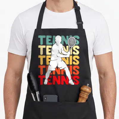 Tablier de cuisine noir avec silhouette blanche joueur de tennis et texte TENNIS en dégradé vertical.