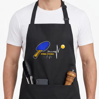 Tablier de cuisine noir avec raque bleue orange et inscription PING PONG Life sur fond gris uni
