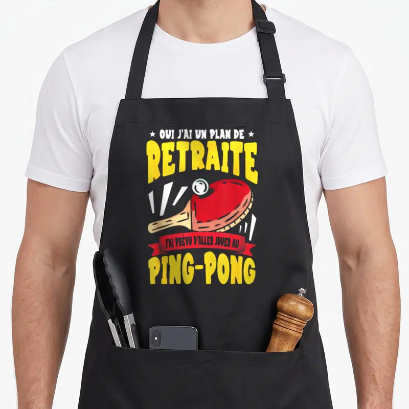 Tablier de cuisine noir avec une raie rouge et le texte « Oui j'ai un plan de retraite » en lettres jaunes.