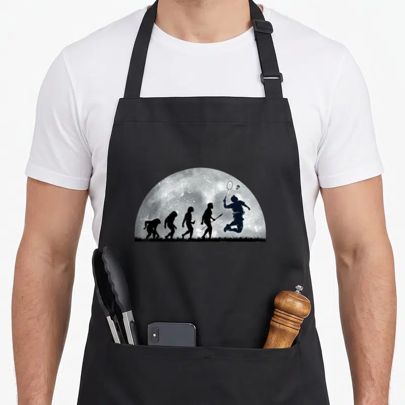 Tablier de cuisine noir avec illustration Evolution du badminton en silhouettes noires sur fond lunaire.