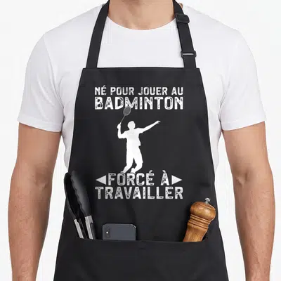 Tablier de cuisine noir avec une silhouette blanche de joueur de badminton et du texte humoristique en blanc.