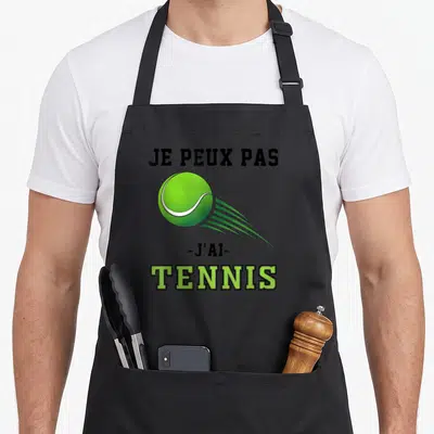 Tablier de cuisine noir avec une balle de tennis verte et le texte Je peux pas j'ai tennis imprimé en noir et vert.
