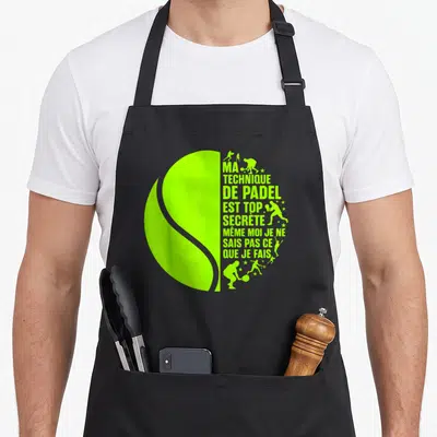 Tablier de cuisine noir avec motif balle de padel vert fluo et texte Ma Technique De Padel Est Top Secrète