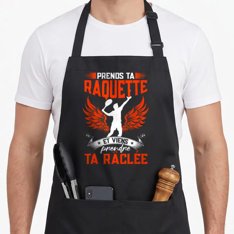 Tablier de cuisine noir avec silhouette ailée tenant une raquette et texte orange Prends ta raquette et viens prendre ta râclée.