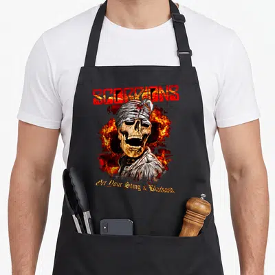 Tablier de cuisine noir avec un crâne bandé, des flammes rouges et le mot Scorpions en lettres brûlantes.