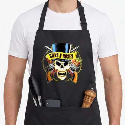 Tablier de cuisine noir avec tête de mort coiffée d'un chapeau haut-de-forme et des revolvers croisés.
