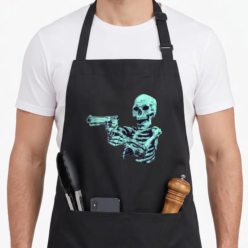 Tablier de cuisine noir avec illustration d'un squelette turquoise tenant un pistolet revolver.