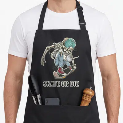 Tablier de cuisine noir avec un squelette en casquette et planche à roulettes sous le motif Skate or Die.