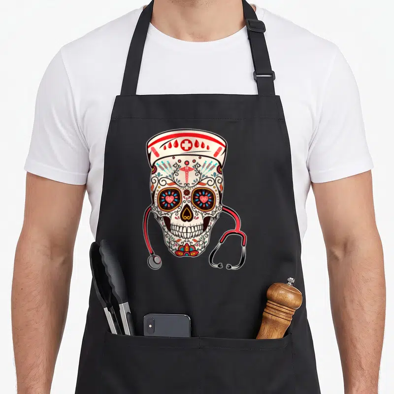 Tablier de cuisine noir avec illustration d'un crâne en sucre portant une casquette médicale et un stéthoscope rouge.