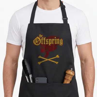 Tablier de cuisine noir avec un crâne hurlant rouge, os croisés jaunes et typographie gothique dorée.