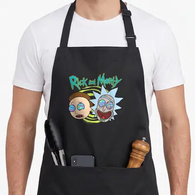 Tablier de cuisine noir avec Rick et Morty aux yeux colorés et texteRick and Morty en lettres vertes ondulantes.